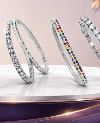 Silver bangles and bracelets displayed on a marble stand